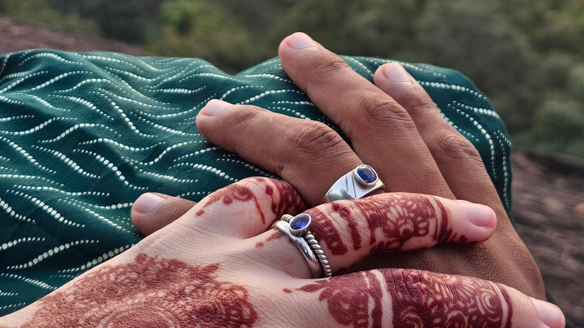 Home 2 Sarah and Salman from Soul and Spicy are holding hands, each wearing a silver ring with stones, and Sarah's hand is covered in mehendi.